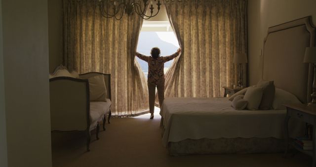 Rear view of caucasian senior woman opening window curtains at home - Download Free Stock Photos Pikwizard.com