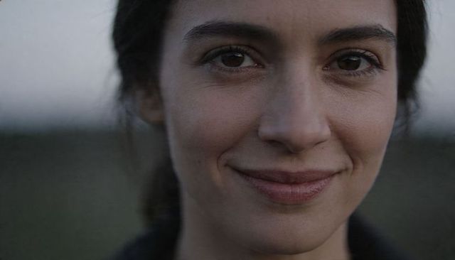 Close-up woman gazing softly at dusk with calm moody smile for intimate lifestyle branding