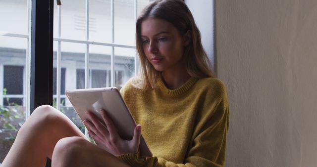 Young Woman Relaxing Near Window Reading Tablet - Download Free Stock Images Pikwizard.com