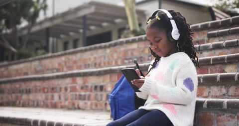 Young girl engaged with tablet outdoors