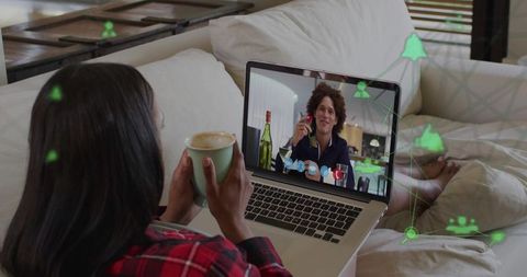 Cozy remote video call woman sipping latte on sofa chatting with man holding wine glass