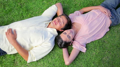 Relaxed Couple Resting on Grassy Field