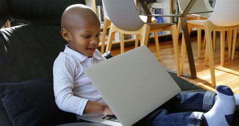 Happy African American Boy Using Laptop in Comfortable Home Setting