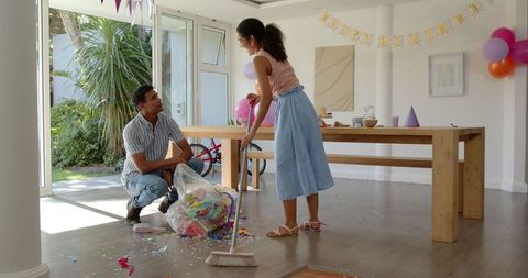 Couple Cleaning Up After Celebration in Decorated Room