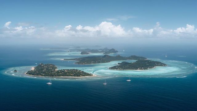 Aerial panorama revealing turquoise lagoon channels, lush tropical islands and sailboats