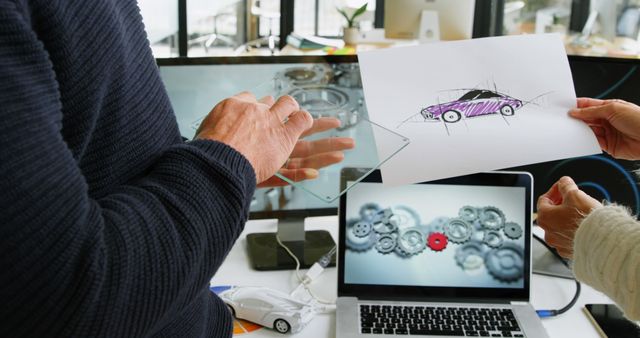 A middle-aged man presents a car design concept to a colleague, with copy space. They are collaborating in a creative workspace, surrounded by technology and design elements.