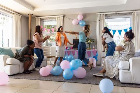Cheerful Female Friends with Infants Celebrating in Decorated Living Room