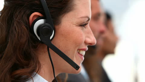Smiling Call Center Operator Using Headset in Modern Office