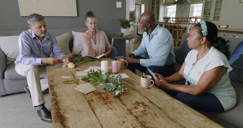 Diverse seniors planning celebration at home with coffee