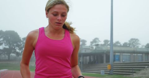 Caucasian Female Athlete Running on Track in Sports Venue Fog - Download Free Stock Images Pikwizard.com