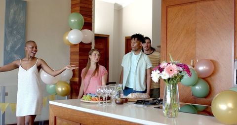 Friendly Home Celebration with Diverse Group Enjoying Snacks