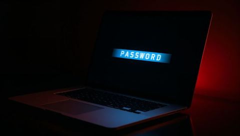 Glowing password login on dark laptop screen with blue backlight and red accent