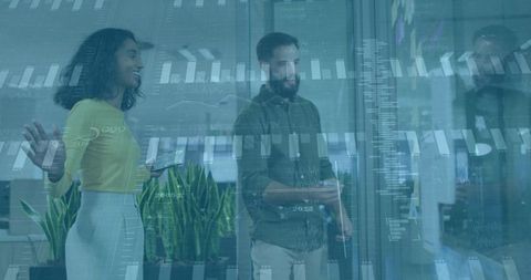 Professionals analyzing data on glass screen in modern office