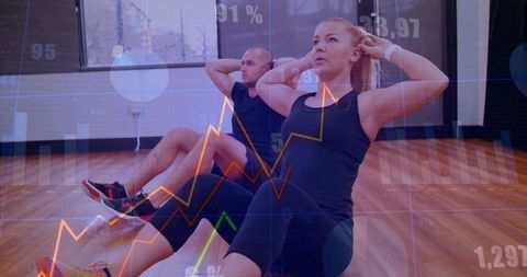 Partners performing core crunches with fitness data overlays in bright gym studio