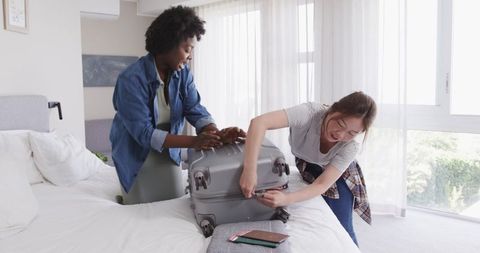 Joyful Couple Packing Suitcase for Vacation at Home