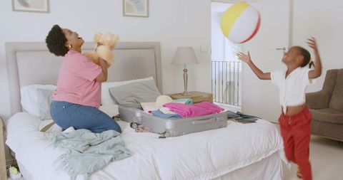 Family Packing Suitcase for Vacation in Bedroom with Joyful Atmosphere