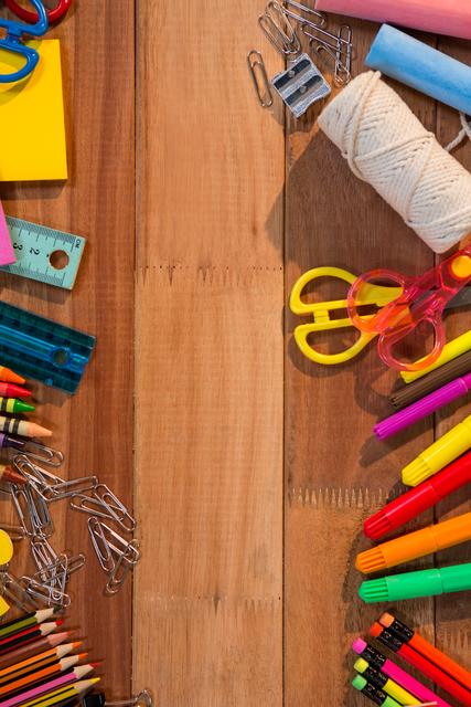 Various colorful stationery items are arranged on a wooden table. This image is perfect for back-to-school promotions, office supply advertisements, and educational materials. It can also be used in blogs or articles about organization, creativity, and educational tools.
