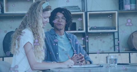 Young professionals collaborating in creative coworking studio with digital network overlay