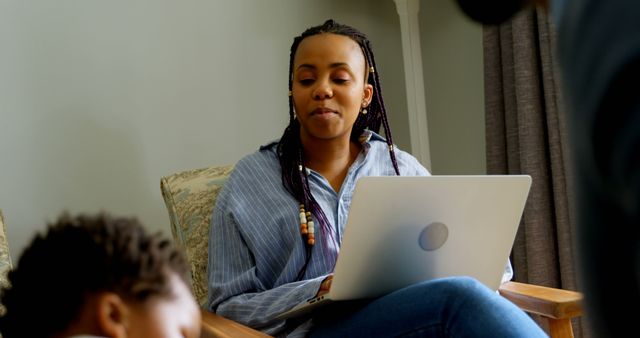 Young Woman Working on Laptop While Caring for Sibling at Home - Download Free Stock Images Pikwizard.com