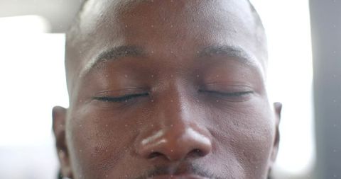 Close-up serene male portrait with eyes closed highlighting skin texture and natural light