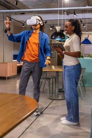 Black colleagues trying VR headset during team collaboration in modern office