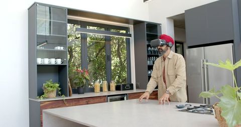 Man Wearing VR Headset Experiencing Virtual Reality in Modern Kitchen