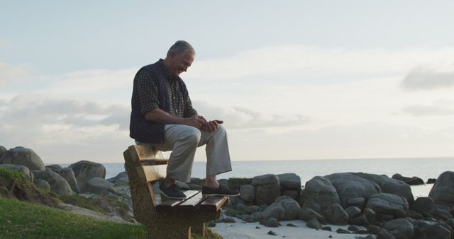 Senior man sitting on beachside bench enjoying sunset - Download Free Stock Images Pikwizard.com