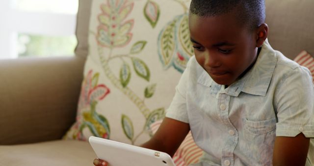 African American Child Using Tablet on Couch with Decorative Cushions - Download Free Stock Images Pikwizard.com