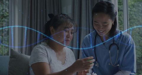 Home nurse assisting woman with medication while telehealth dna wave visualizes health