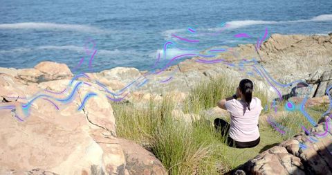 Woman Exploring Rocky Coastline with Binoculars