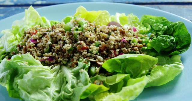 A healthy quinoa salad served on a bed of crisp lettuce leaves, with copy space. Fresh ingredients and vibrant colors make this dish an appealing choice for a nutritious meal.