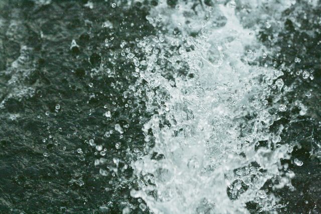 This image captures a dynamic scene of water droplets splashing in motion. Suitable for use in projects involving themes of motion, fluidity, nature, and freshness. Ideal for websites, advertisements, and promotional materials on water conservation, environmental awareness, or products related to water.