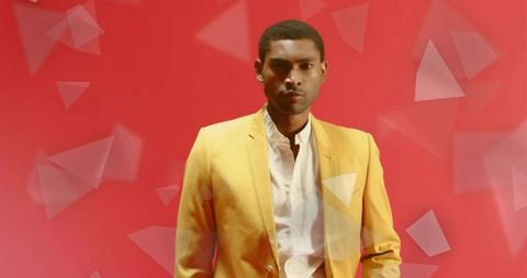 Stylish man in yellow blazer with geometric triangles on red background