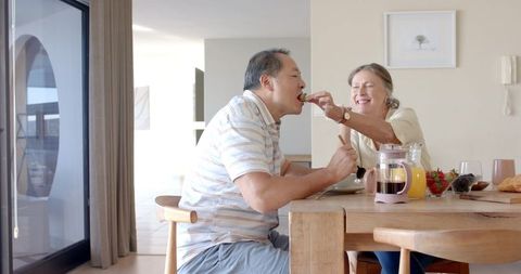 Senior couple sharing meal at home embracing intimacy and companionship