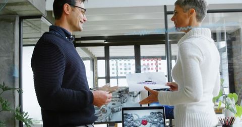 Engineers Discuss Gear Schematics in Contemporary Office