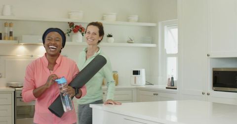 Joyful Friends Preparing for Home Yoga in Bright Kitchen