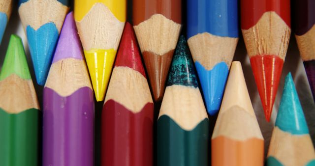 A vibrant array of sharpened colored pencils are closely arranged, showcasing a spectrum of hues. These art supplies symbolize creativity and are essential tools for artists, students, and anyone engaged in visual expression.