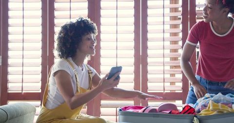 Two Women Preparing for Exciting Vacation at Home with Suitcase