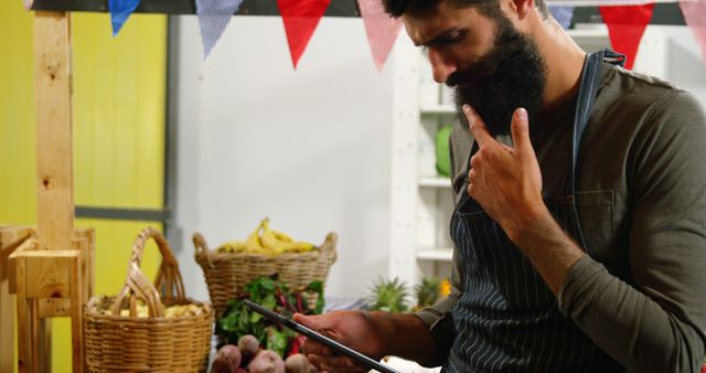 Male staff using digital tablet at organic market