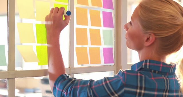 Woman Brainstorming with Sticky Notes on Glass Window - Download Free Stock Images Pikwizard.com