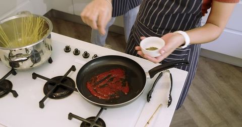 Two People Cooking Delicious Homemade Pasta in Modern Kitchen