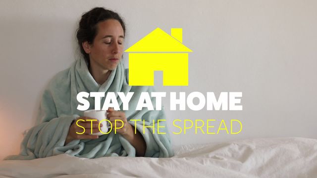 Caucasian woman wrapped in blanket, sitting on bed with social distancing message overlay. The visual promotes key messages such as 'Stay at Home' and 'Stop the Spread,' relevant during the Covid 19 pandemic. Ideal for government health campaigns, educational materials on Covid 19 guidelines, and social media postings advocating for health and safety during outbreaks.