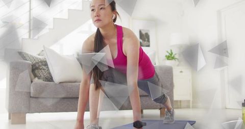 Mid-adult asian woman doing forward lunge with earbuds during focused home workout and warmup