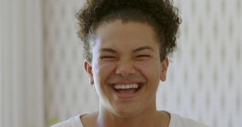 Young man smiling confidently with curly hair