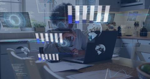 Senior woman working remotely on laptop with holographic data overlays in kitchen workspace