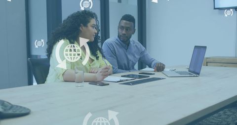 Coworkers Discussing Reports on Laptop in Modern Office