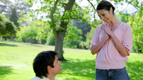 Man Serenading Girlfriend in Peaceful Park Scene