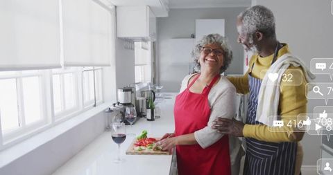 Happy Senior Couple Cooking in Bright Kitchen with Wine