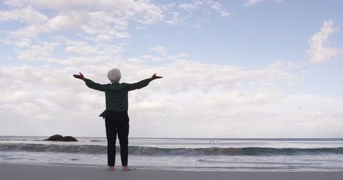 Senior Woman Enjoying Tranquil Beach View with Open Arms - Download Free Stock Images Pikwizard.com