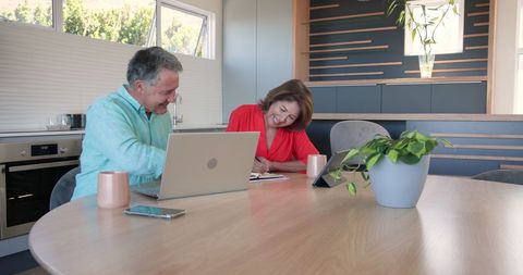 Senior Couple Celebrating Success with Technology at Home